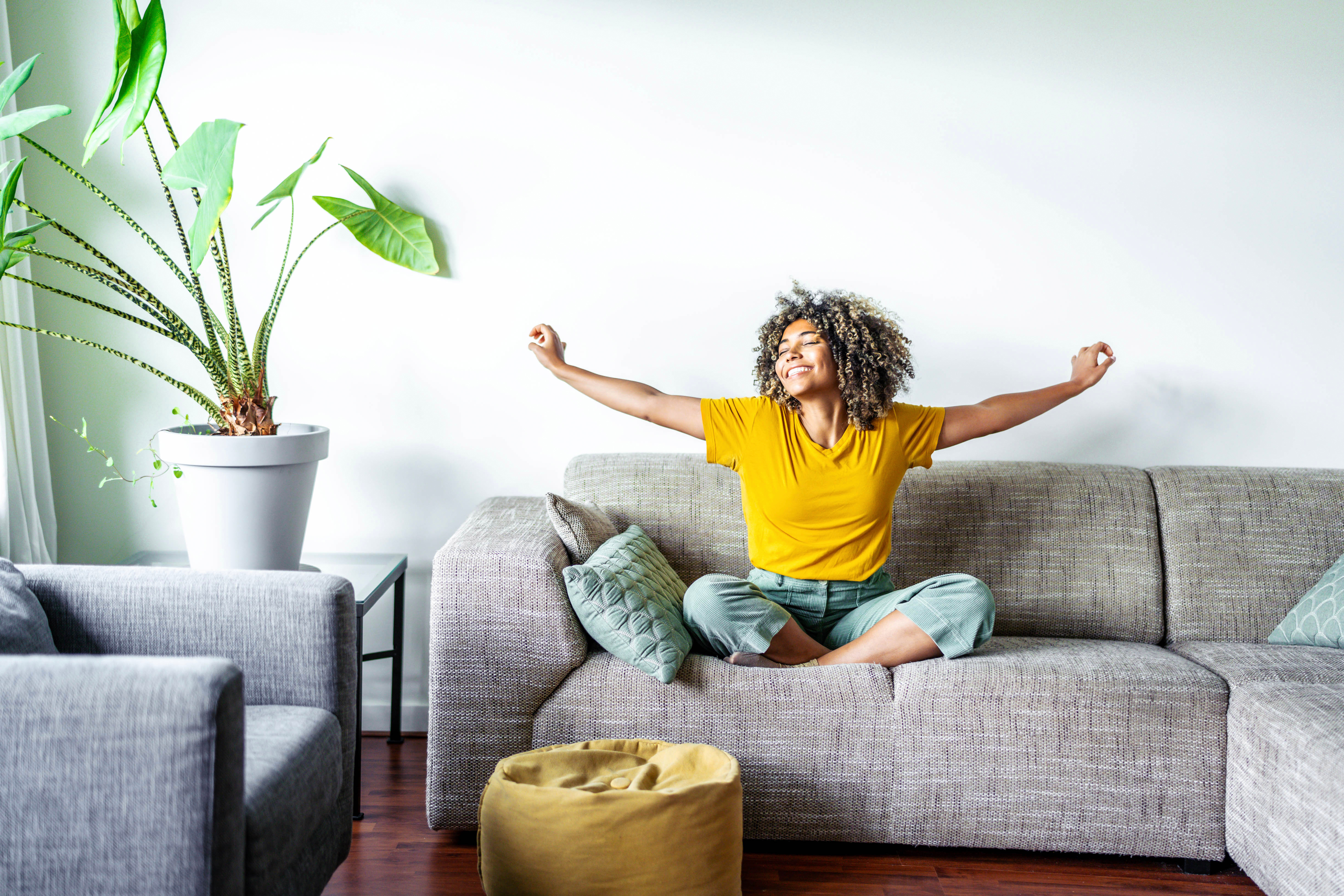 A woman happy on her couch - Benefits of at home hydration with Vida-Flo.
