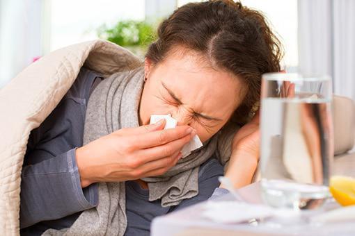 A woman feeling sick - learn how to prevent and treat common respiratory infections.