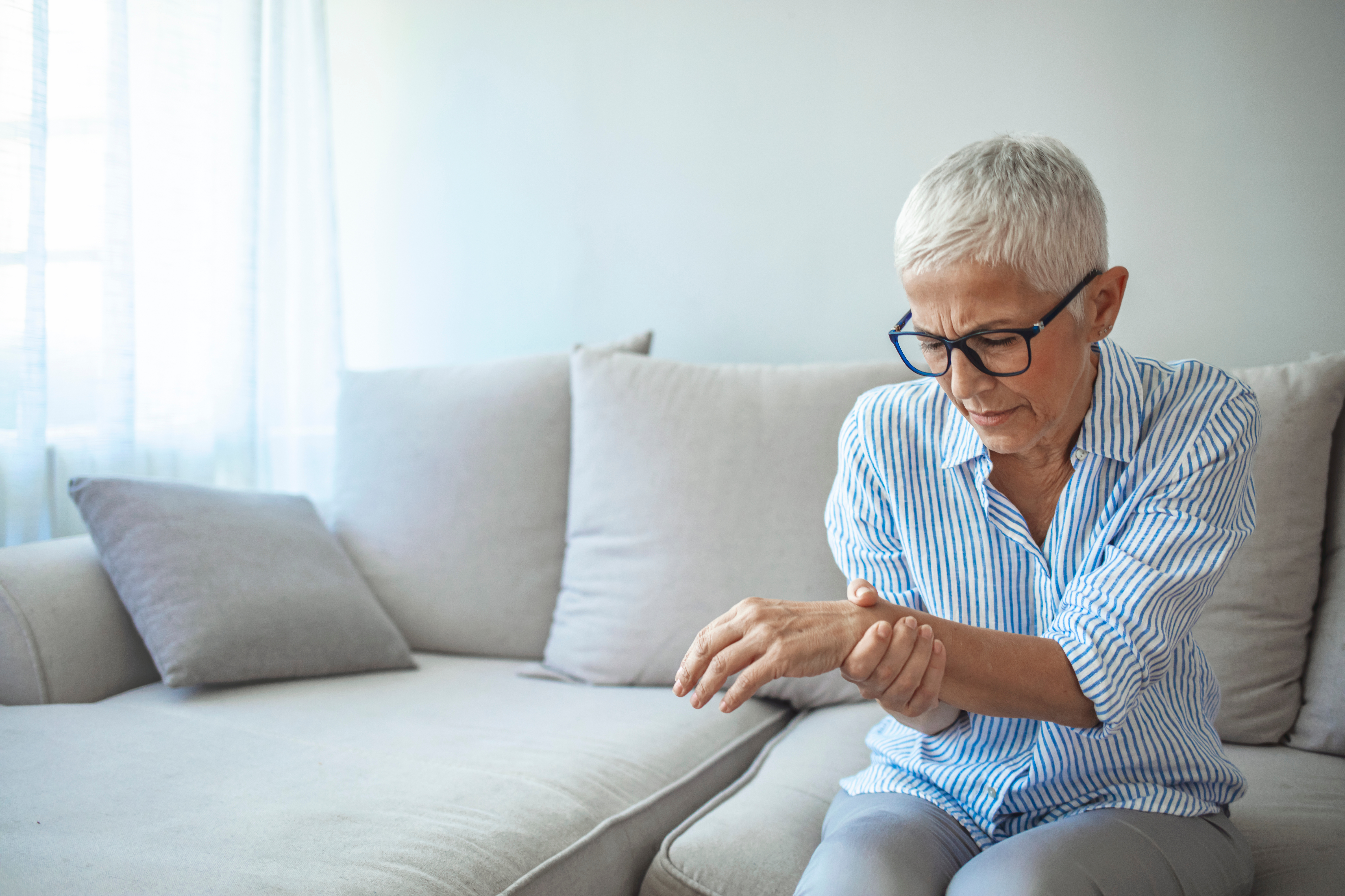 An older woman with wrist pain - book with Vida-Flo and experience the relief that our IV hydration treatment for gout in Buckhead, GA can bring you.