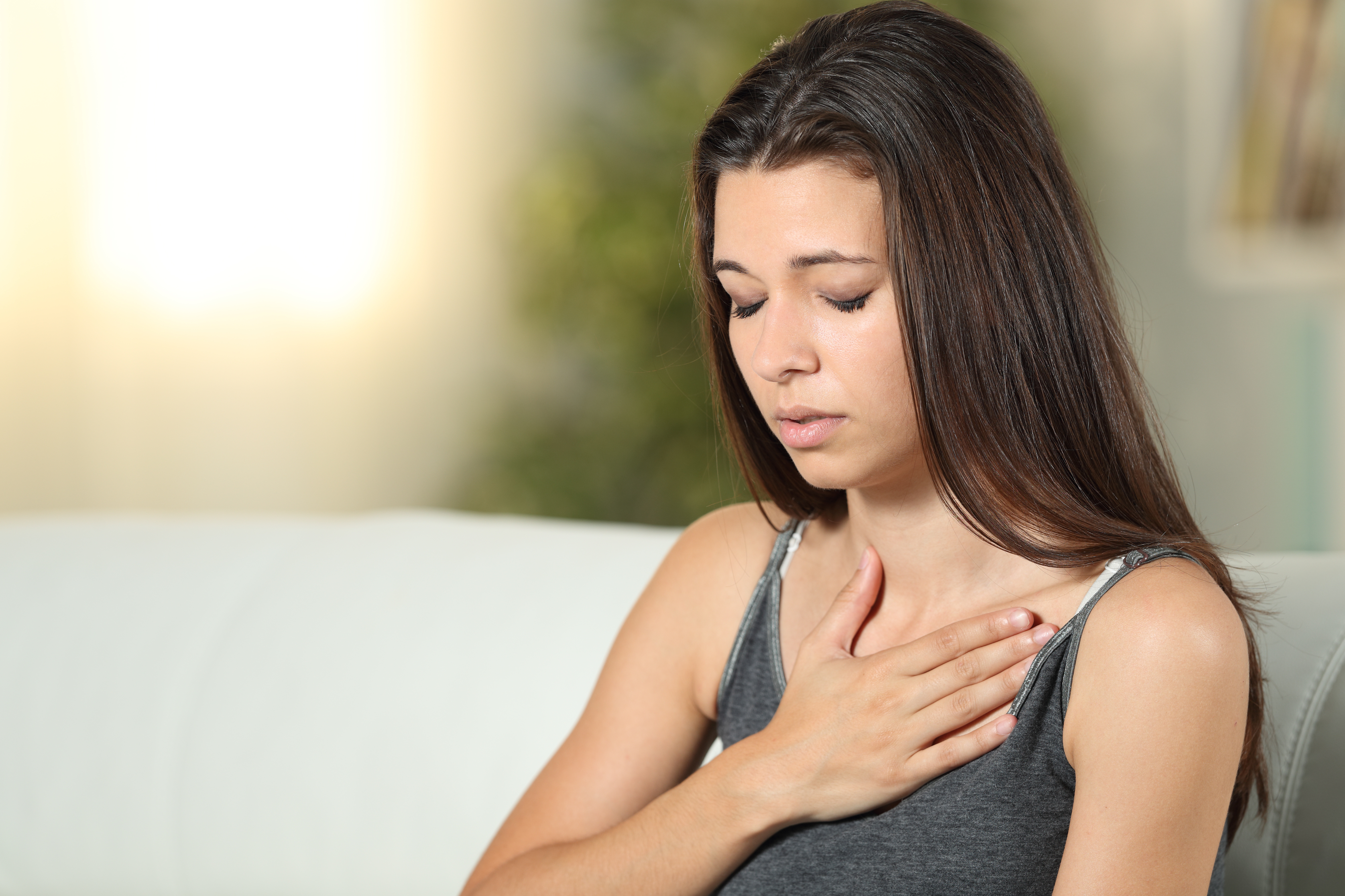 A younger woman experiencing a rapid heartrate, a common symptom of POTS - find relief with Vida-Flo's Buckhead iv hydration for pots disease.